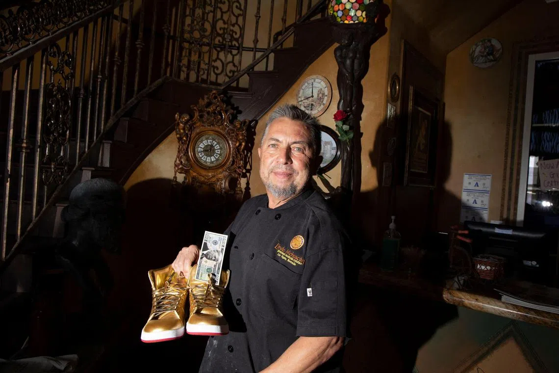 Javier Barajas, owner of Il Toro E La Capra poses with his Trump Sneakers at the restaurant where Donald Trump spoke last summer in Las Vegas, Nevada, on October 11.
