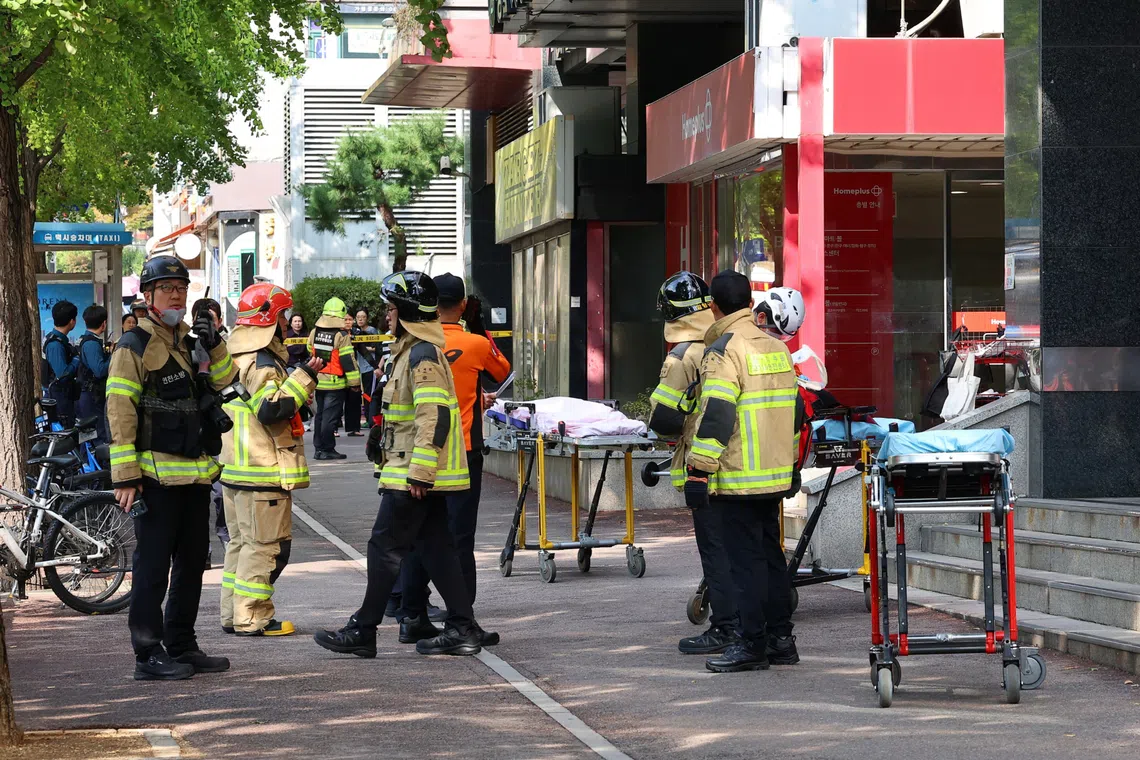 Firefighters and policemen gather outside the scene where the stabbing incident occurred in Incheon, South Korea, on Oct 13.
