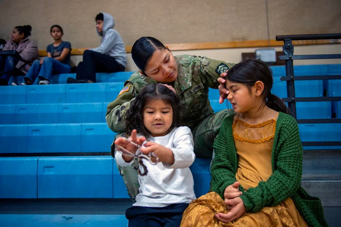 First Sergeant Rosa Cortez with two of her children, Celestina Rodriguez (left), 4, and Carmelena Rodriguez, 7, at a soccer game in which her son was playing, in The Dalles, Oregon, on Dec 6, 2025.
