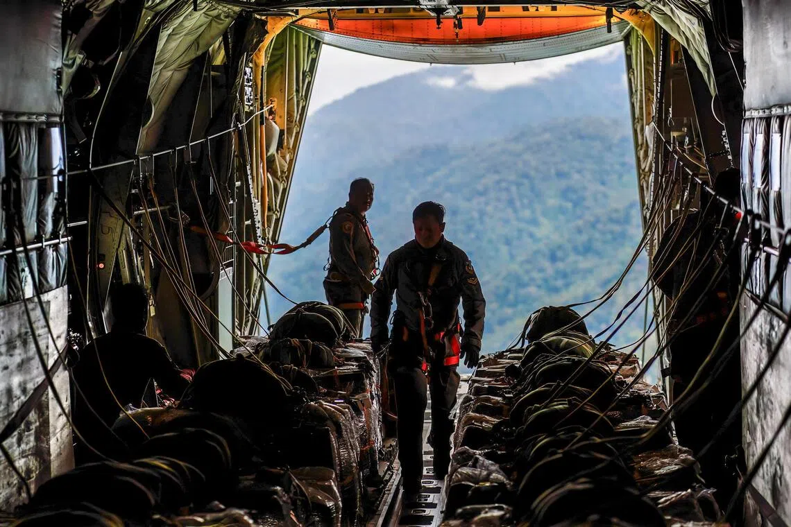 Indonesian Air Force personnel prepare to airdrop aid from a military transport aircraft in the flood-affected and isolated Gayo Lues area in Aceh on Dec 7.