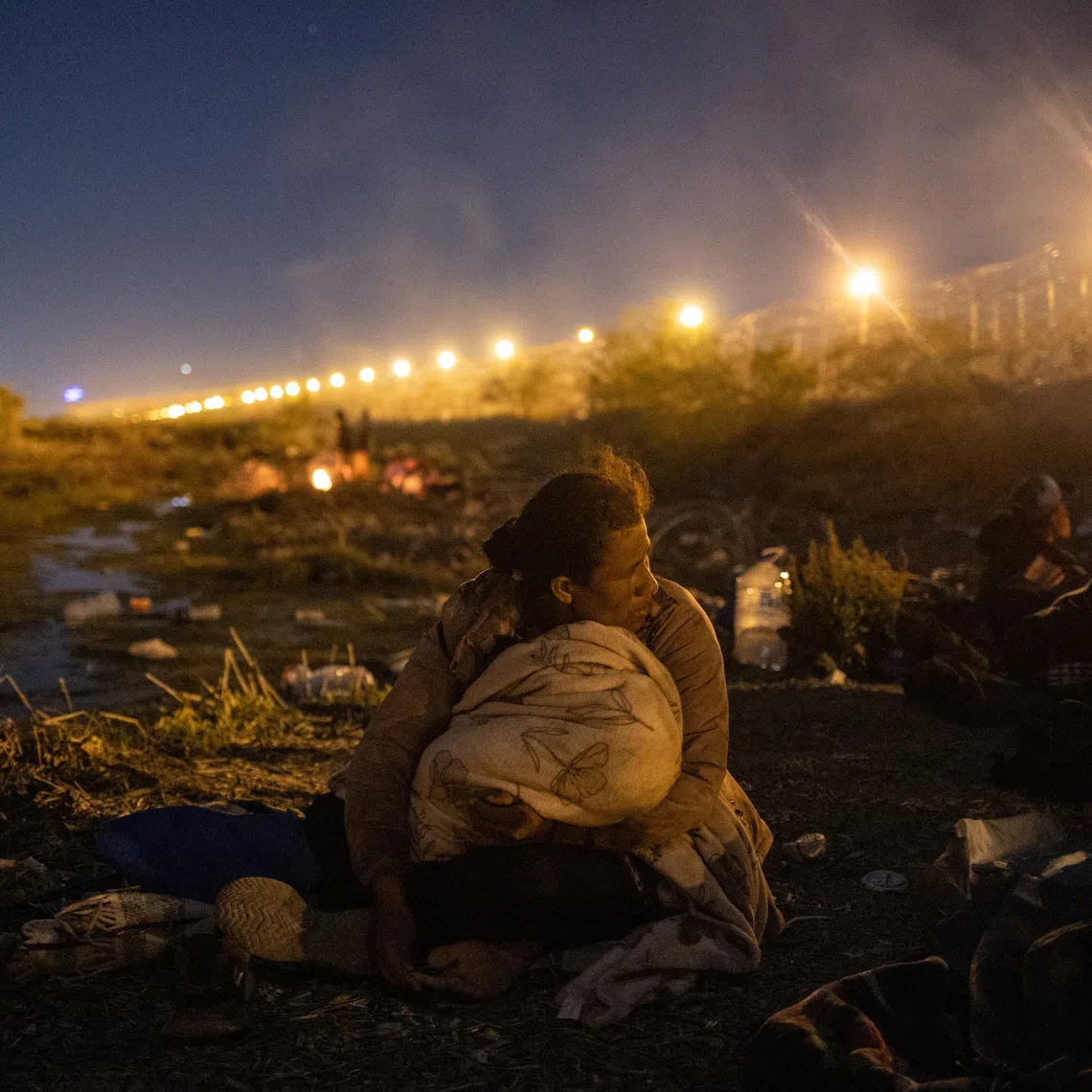 Fabiola, a 30-year-old migrant from Nicaragua, looks towards the U.S. while holding her two-year-old daughter Carolina from the riverbed of the Rio Grande while searching for an entry point into the U.S. from along the international boundary between Ciudad Juarez, Mexico and El Paso, Texas, April 20, 2024. REUTERS/Adrees Latif