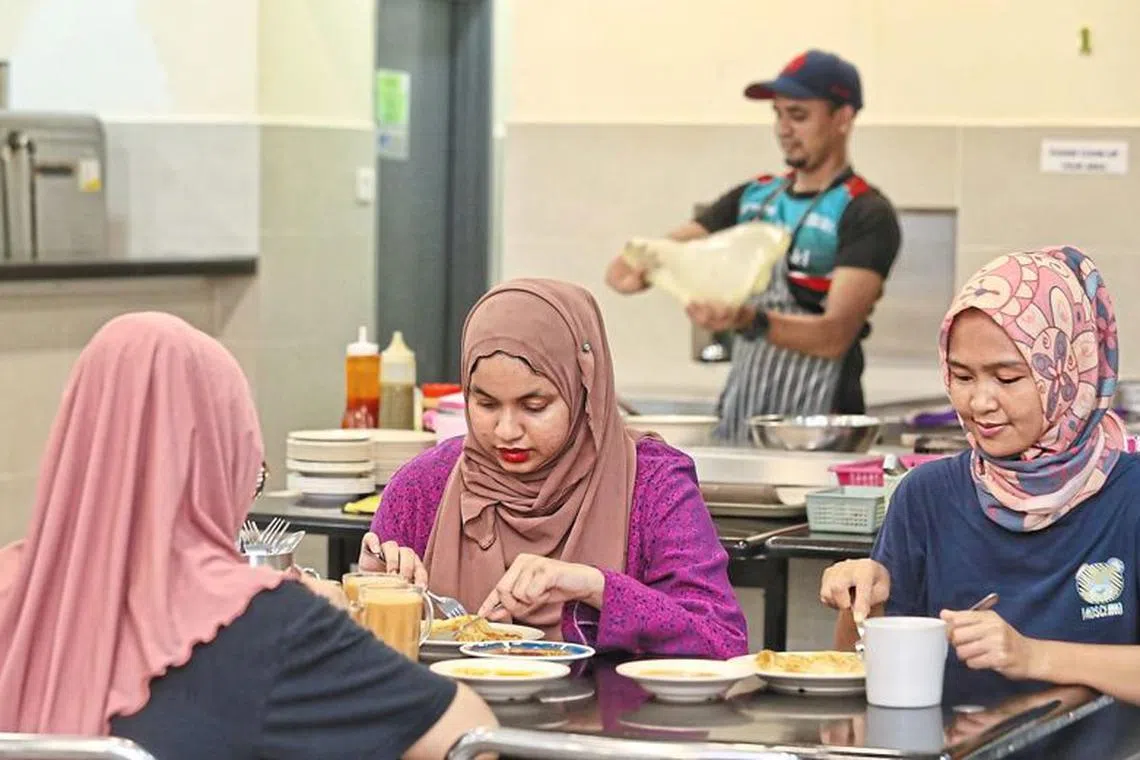 A flip from the norm: Customers enjoying their meal as a roti canai maker flips more of the flatbread at a restaurant.