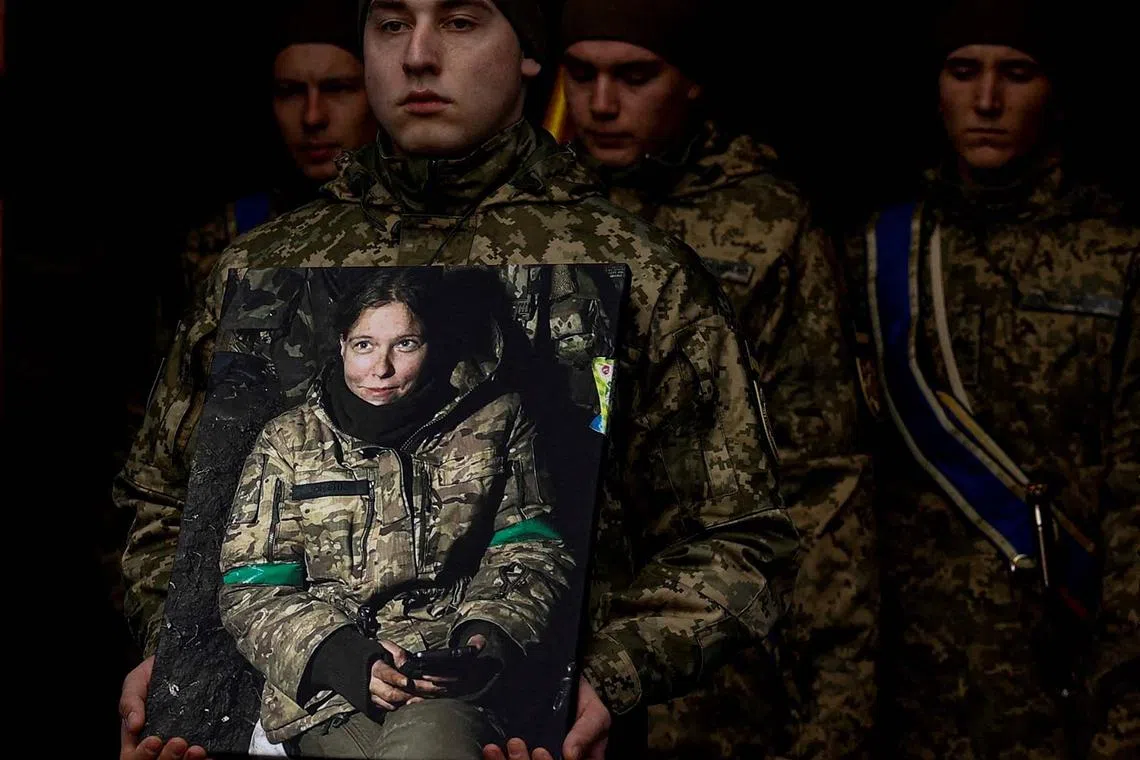 A Ukrainian serviceman carries a portrait of Diana Savita Wagner, a German combat medic, who joined Ukrainian Armed Forces as a volunteer and was killed by Russian troops in the country's East, amid Russia's attack on Ukraine, during her funeral ceremony in Kyiv, Ukraine February 14, 2024. REUTERS/Valentyn Ogirenko TPX IMAGES OF THE DAY