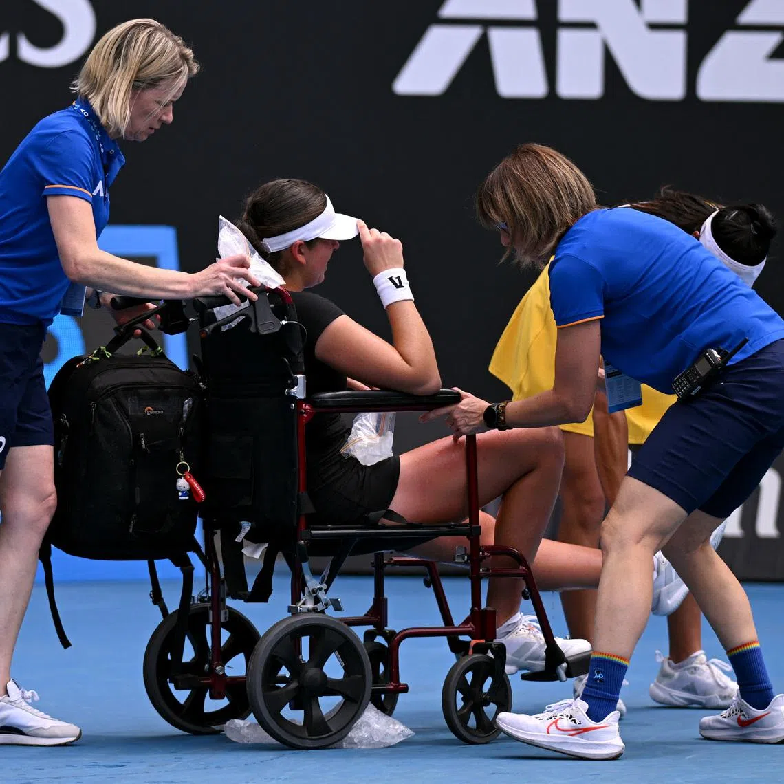 Tennis - Australian Open - Melbourne Park, Melbourne, Australia - January 19, 2026 Canada's Marina Stakusic is assisted onto a wheelchair after retiring from her first round match against Australia's Priscilla Hon REUTERS/Jaimi Joy