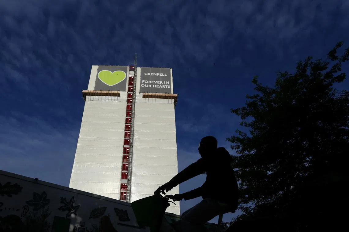 A person cycles near the covered remains of Grenfell Tower, on the day of the publication of the second report of the UK public inquiry into the deadly 2017 Grenfell fire, in London, Britain, September 4, 2024. REUTERS/Toby Melville