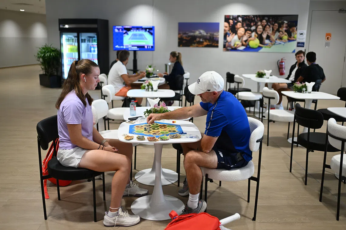 Australian tennis player Talia Gibson and her coach Jarrad Bunt in the player's lounge playing a board game called Catan on Sept 22, 2026.