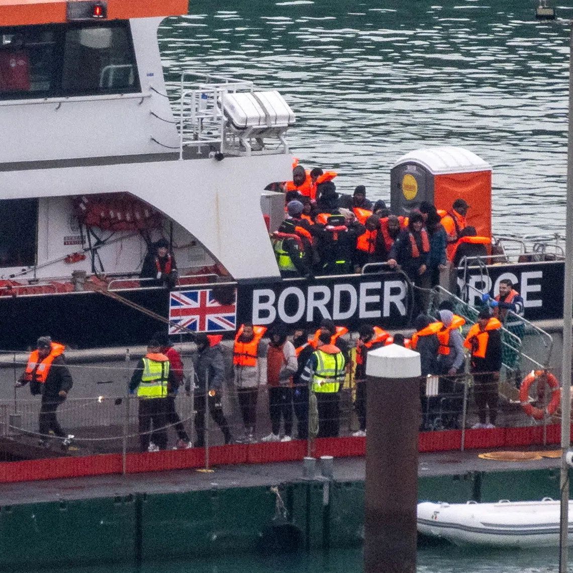 FILE PHOTO: Migrants disembark from a British Border Force vessel as they arrive at the Port of Dover, in Dover, Britain, December 29, 2024. REUTERS/Chris J. Ratcliffe/File Photo