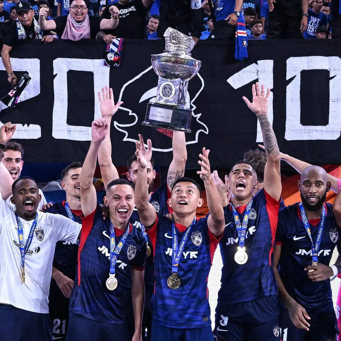 Johor Darul Ta’zim’s players celebrating with the trophy after beating Kuching City in the opening football match of the Malaysia Super League on Aug 21.