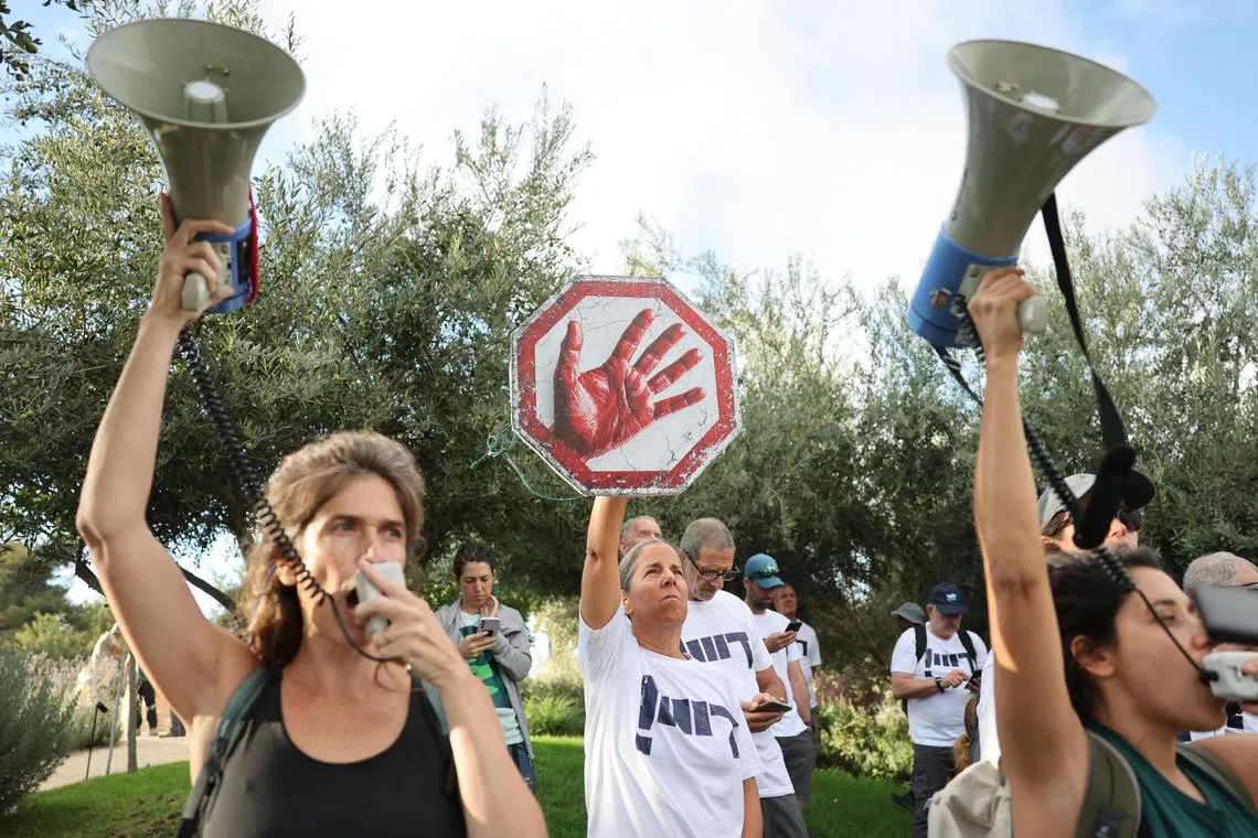 Protesters in Jerusalem hold placards and loudspeakers in a 'day of rage' demonstration calling on the government to sign a hostage-release and ceasefire deal.
