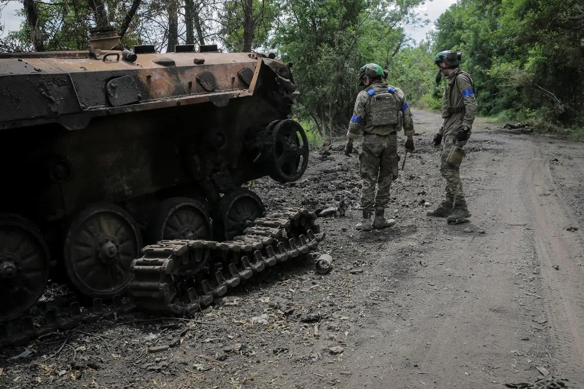 Ukrainian servicemen check a destroyed Russian a BMP-2 infantry fighting vehicle  near the front line, in the newly liberated village of Storozheve in Ukraine's Donetsk region.