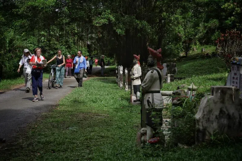 A public tour being conducted at the Bukit Brown cemetery in 2024. The writer argues that Bukit Brown’s unique features can also be used to address climate change.