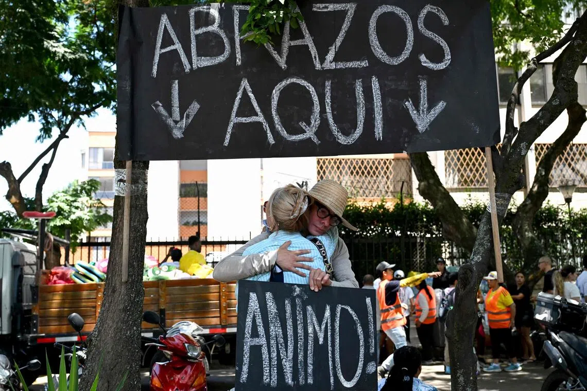 One man offering free hugs spends his days under the shade of trees and a cardboard sign that states: “HUGS HERE.”