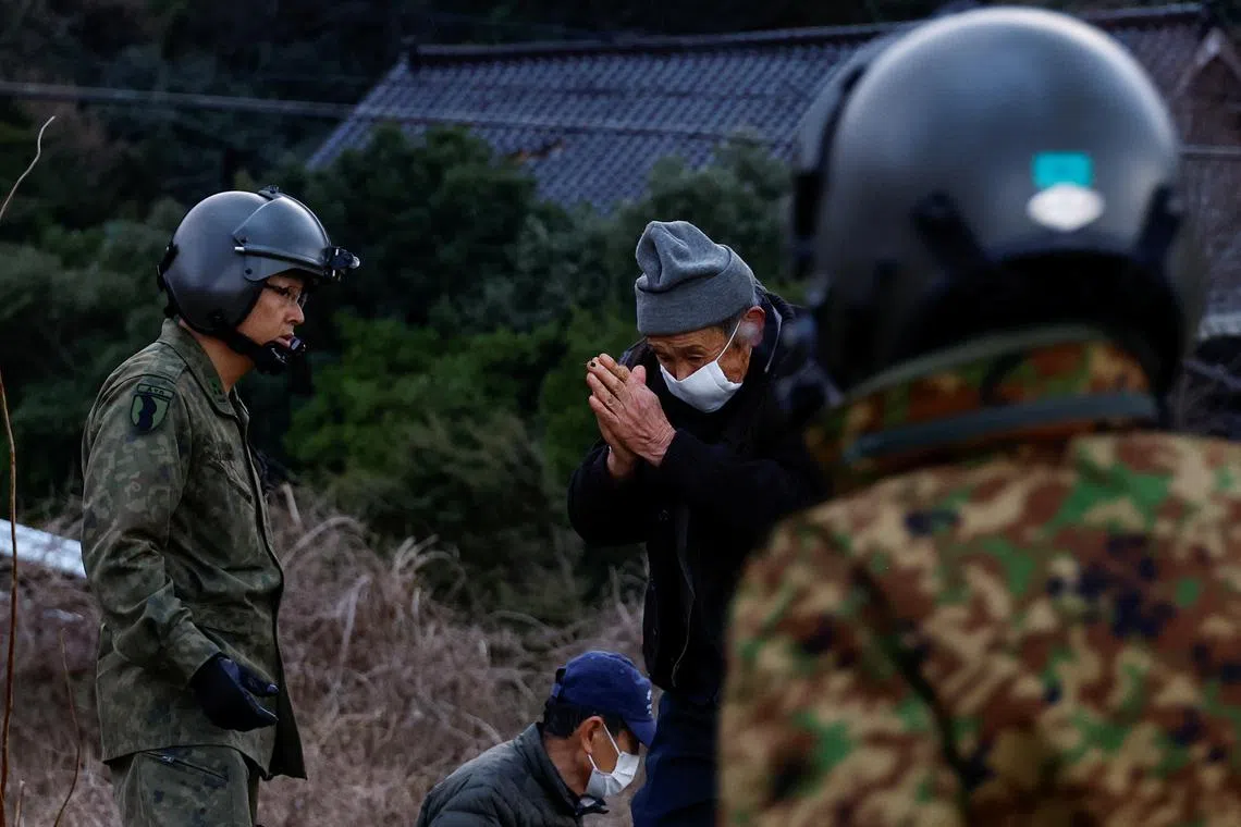 A resident in Fukamimachi, a village isolated after the earthquake, gesturing in gratitude as he heads to a Japan Self-Defense Forces (JSDF) rescue helicopter, in Wajima, Ishikawa Prefecture, Japan, Jan 6, 2024. 