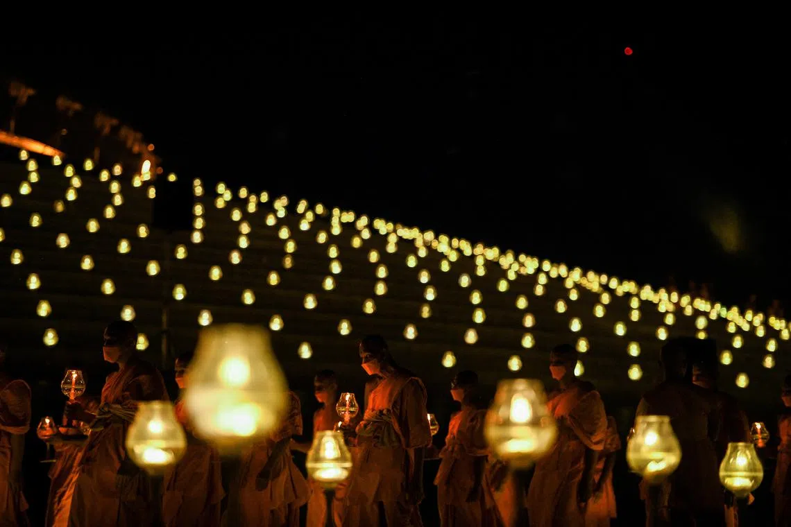 Buddhist monks carrying candles during a ceremony commemorating Vesak Day, an annual celebration of Buddha's birth, enlightenment and death, at the Wat Phra Dhammakaya temple in Pathum Thani province outside Bangkok, Thailand, on June 3, 2023. 