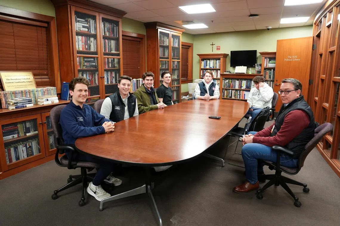 College freshman, Tyler Delaney, 19, sophomore Tyler Witzgall, 20, junior, John Fitzpatrick, 20, sophomore Michael Leary, 19, sophomore Ian Pomfret, 20, and sophomore Artemius Gehring, 20, pose for a picture with Reuters reporter Nathan Layne, after an interview as part of a panel of students about their views on the U.S. President Donald Trump's administration, in Manchester, New Hampshire, U.S., March 2, 2026.