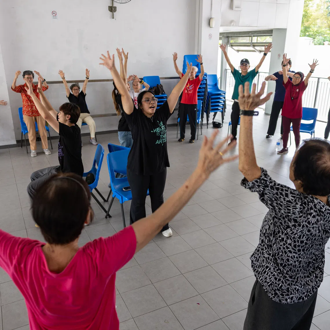 Student trainers Ashley Ng, Shyann Loh and Nureen Binte Abdul Aziz guiding seniors at the launch of a large-scale intergenerational community dance programme by NUS Nursing and Lions Befrienders on Sept 30.