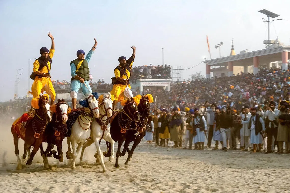 TOPSHOT - Nihang or Sikh warriors ride horses to mark the birth anniversary of the tenth Guru of the Sikhs, Guru Gobind Singh, at the Kangan Ghat in Patna on January 6, 2025. (Photo by Sachin KUMAR / AFP)