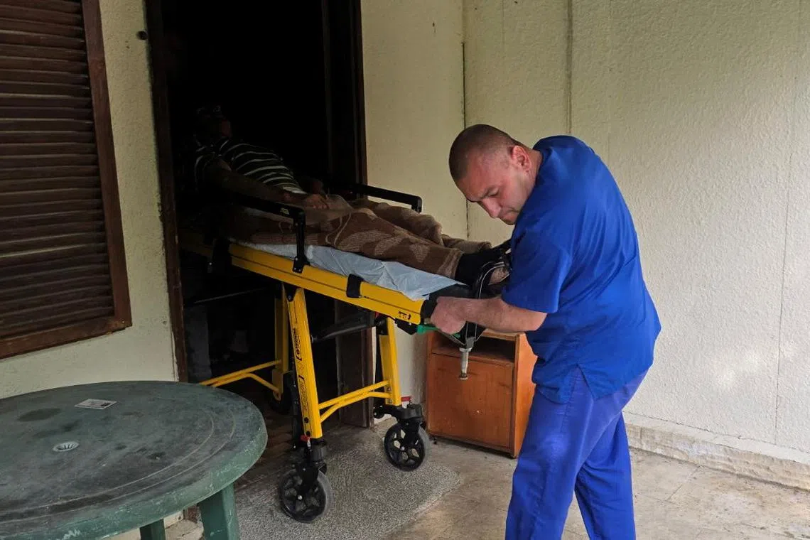 A medic transporting an elderly person outside an illegal hospice in the Bulgarian village of Yagoda on June 9.