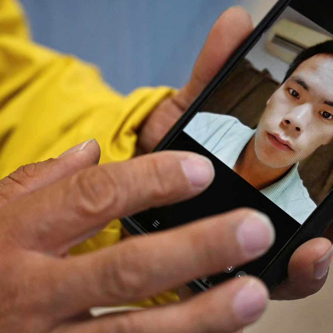 Yanfeng Ge shows a picture of his brother, Chaofeng Ge, who was found dead in ICE custody in 2025, in Dickens, Texas, U.S. May 26, 2026.  REUTERS/Annie Rice