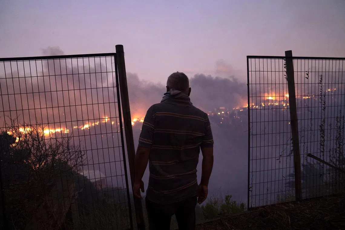 An resident watches a forest fire in Vina del Mar, Chile, 22 December 2022. The National Forest Corporation reported that 15 hectares have been affected. 