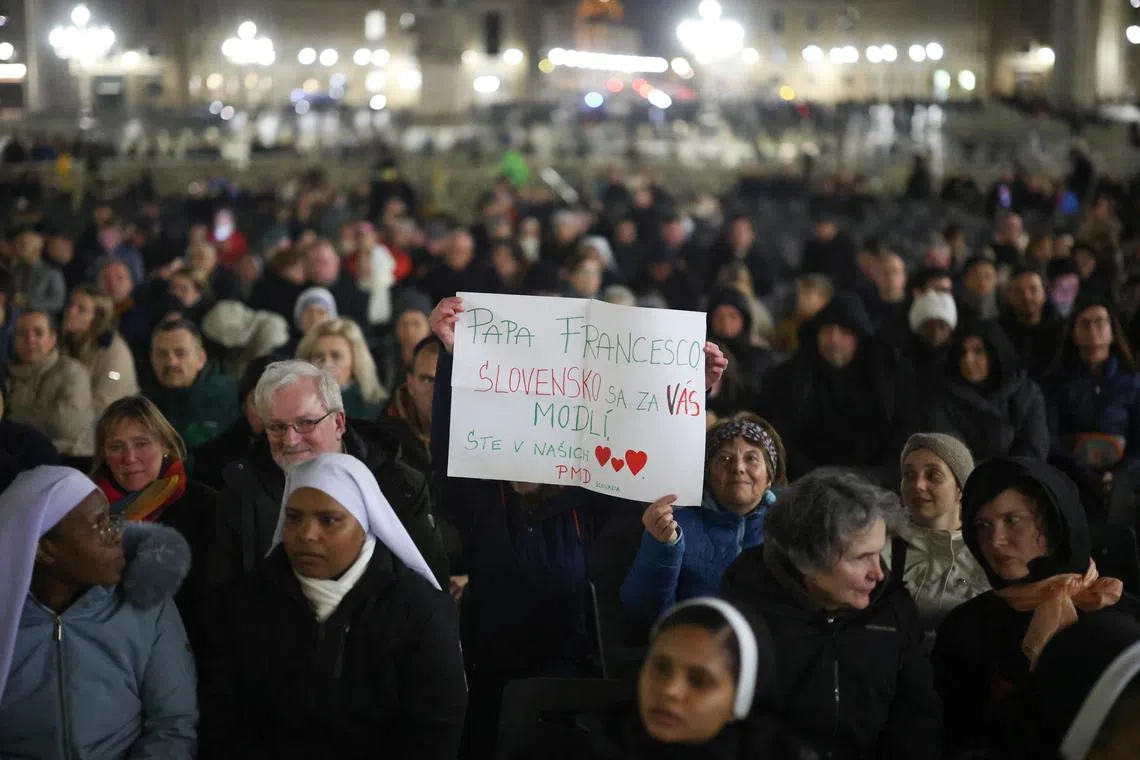 People hold a sign reading "Papa Francis, Slovakia is praying for you" as faithful attend a prayer service in St. Peter's Square, as Pope Francis continues his hospitalization, at the Vatican, on March 3, 2025.