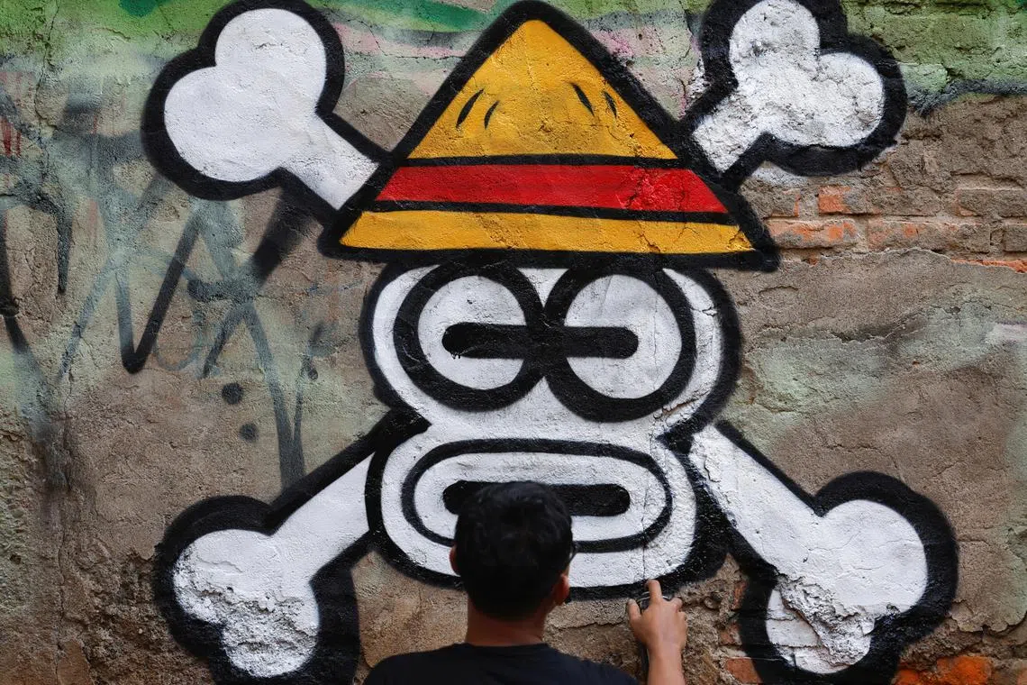 Artist Kemas Muhammad Firdaus, 28, spray-painting a Jolly Roger influenced by the popular Japanese series 'One Piece' in Bekasi. The symbol has been adopted in protest ahead of Indonesia's Independence Day on Aug 17.