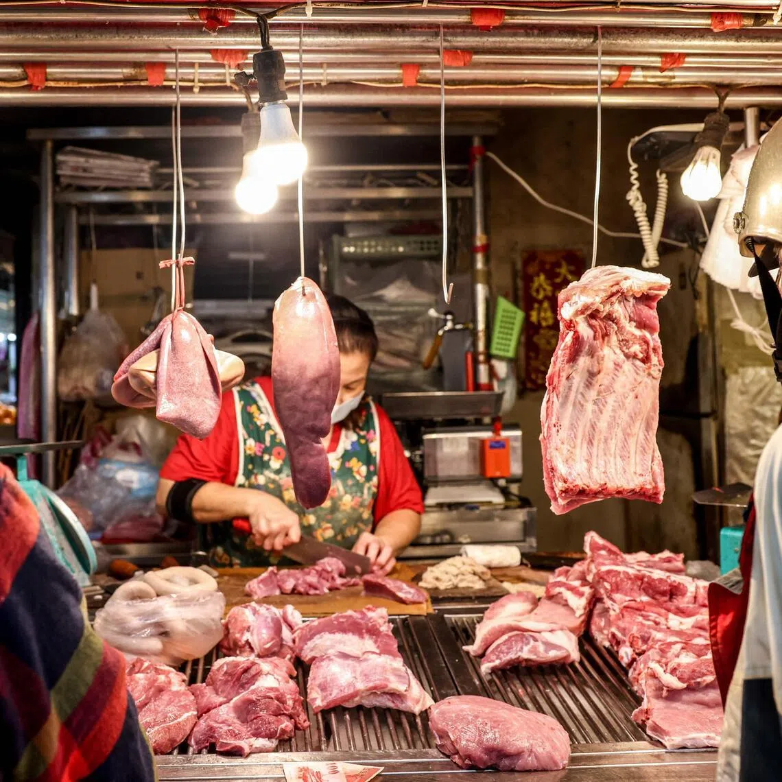 A vendor cuts meat at a pork stall at a local traditional market in Keelung on October 23, 2025. Taiwan has culled dozens of pigs after detecting its first cases of African swine fever, with the agriculture ministry saying on October 23 no other infections have been detected elsewhere on the island.
