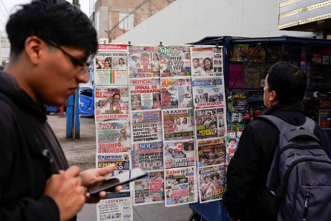 A man looks at a newspaper stand with headlines showing early results of a runoff between conservative presidential candidate Keiko Fujimori and left-wing candidate Roberto Sanchez, as Fujimori kept a slight lead over Sanchez, with over 90% of the votes counted, according to an official tally, in Lima, Peru, June 8, 2026. REUTERS/Leslie Moreno