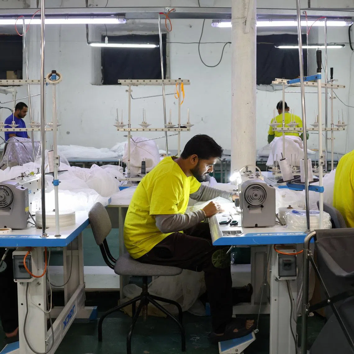 Migrant workers from India sew tulle fabric at a textile factory in the town of Balashikha outside Moscow on Jan 20.