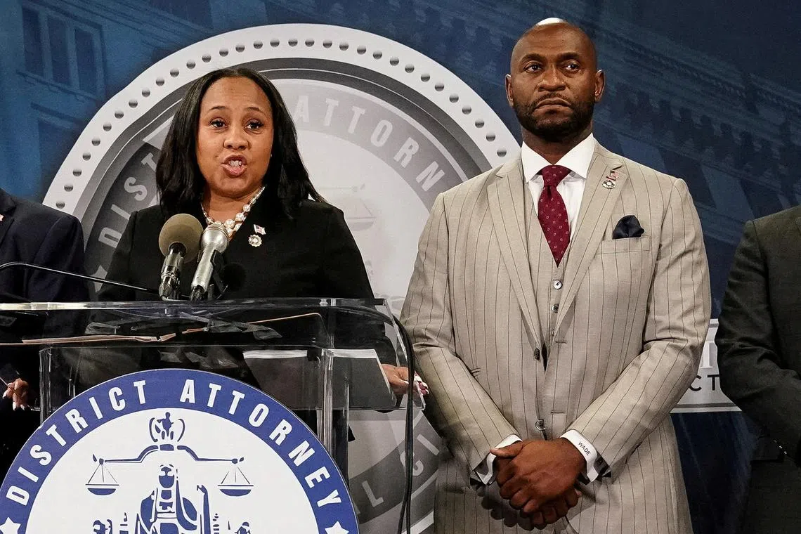 Fulton County district attorney Fani Willis speaks at a press conference next to special prosecutor Nathan Wade.