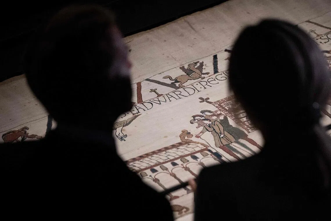 French President Emmanuel Macron (left) and his wife Brigitte Macron viewing sections of the Bayeux Tapestry during a Sept 2 preview event at the British Museum in London.