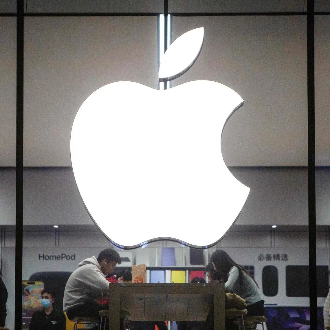 (FILES) This photo taken on October 30, 2023 shows people visiting an Apple store in Shenyang, in China's northeastern Liaoning province. Apple has removed the Meta-owned WhatsApp and Threads from its App Store in China following an order from the country's top internet regulator, Bloomberg reported on April 19, 2024 citing the tech giant. (Photo by AFP) / China OUT