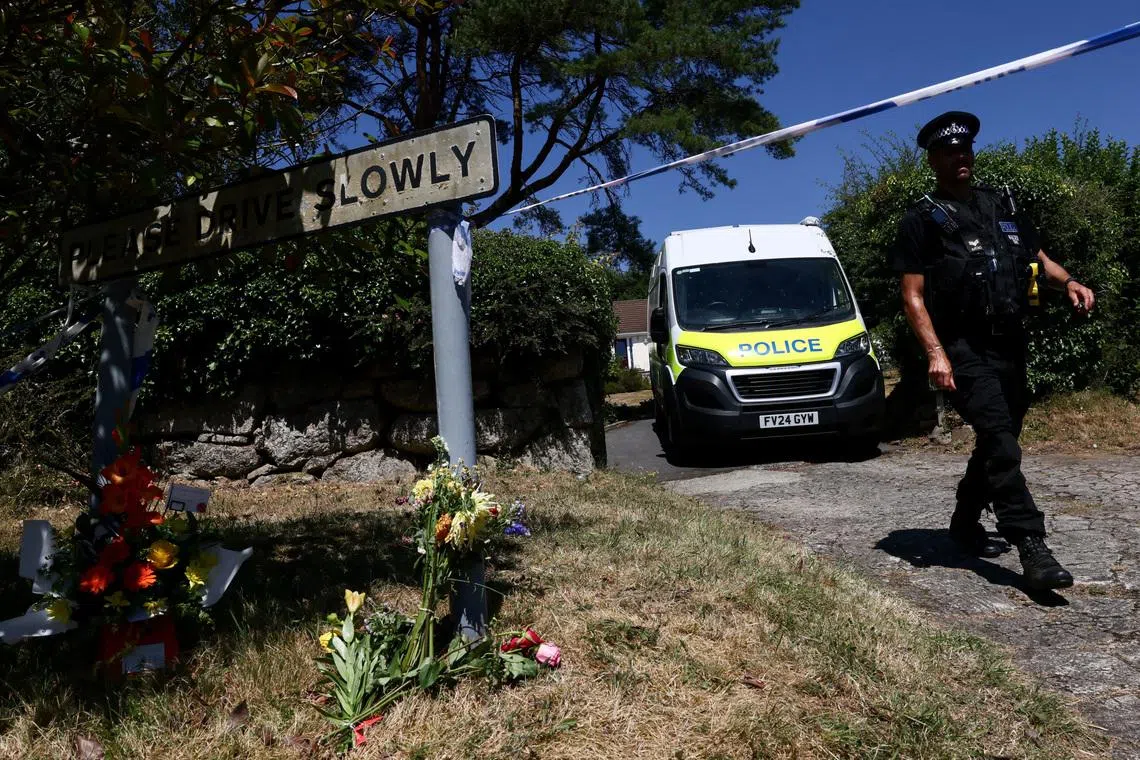 FILE PHOTO: A police officer walks past flower tributes left outside the home of 78-year-old former government minister Ann Widdecombe after she was found dead, as the police investigation continues, in Haytor, Britain, July 11, 2026. REUTERS/Jack Taylor/File Photo