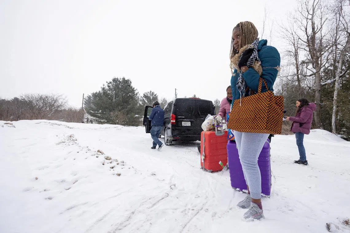 FILE PHOTO: Two women, who state they are from the Republic of Congo, arrive by taxi to cross into Canada from the U.S. border on Roxham Road in Champlain, New York, U.S., February 28, 2023. REUTERS/Christinne Muschi/File Photo
