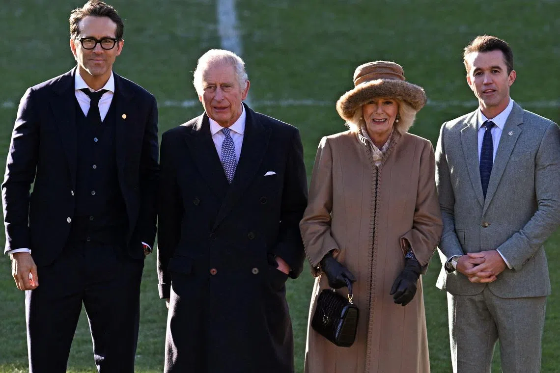 Britain's King Charles III (second from left) and Queen Consort Camilla pose for a photograph with US actors Ryan Reynolds (left) and Rob McElhenney.