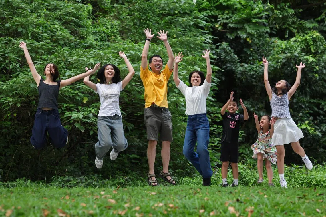 Gerald Ng (third from left) and Debbie Leung (centre) together with their children, (from left) Kate, Jane, Luke, Rose, and Sophie.
