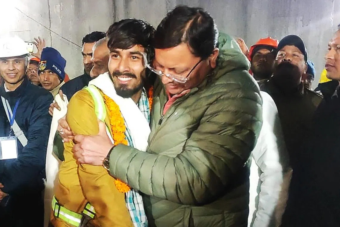 Uttarakhand chief minister Pushkar Singh Dhami (right) embraces a construction worker following his rescue from the collapsed tunnel.