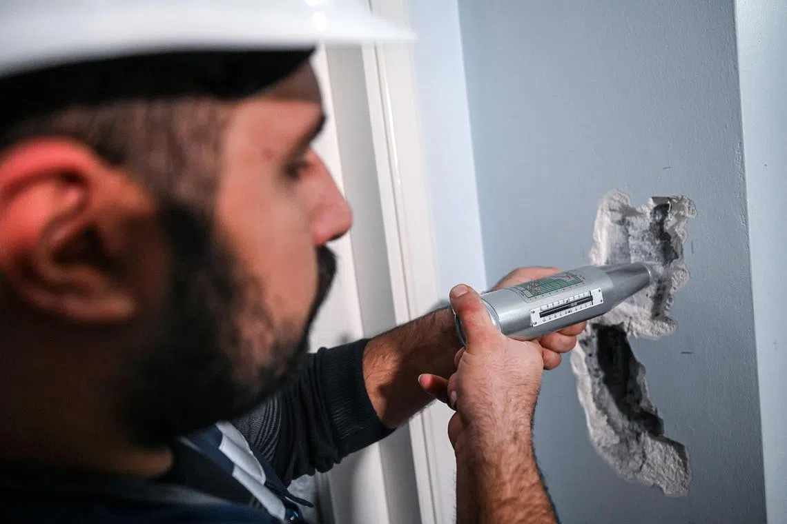 An engineer of Istanbul Metropolitan Municipality checks the pillar of a flat in Istanbul.