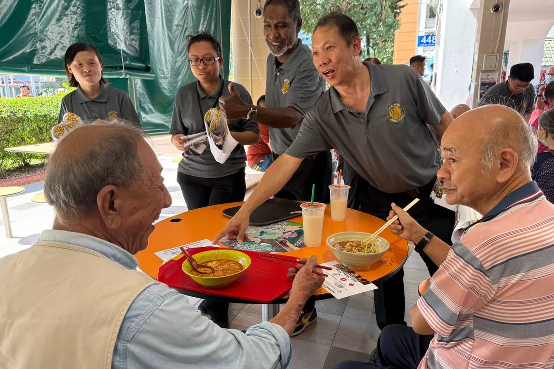 The Singapore United Party deputy-secretary general Darren Soh (right) with party chairman Dr Ridhuan Chandran (second from right) speaking to residents at Chong Boon Market and Food Centre on April 6.