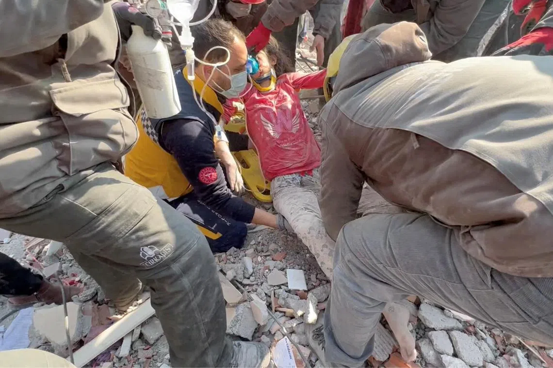 Rescuers help a woman who survived 128 hours under rubble, in Kahramanmaras, Turkey, on Feb 11, 2023, in a still image from video. 
