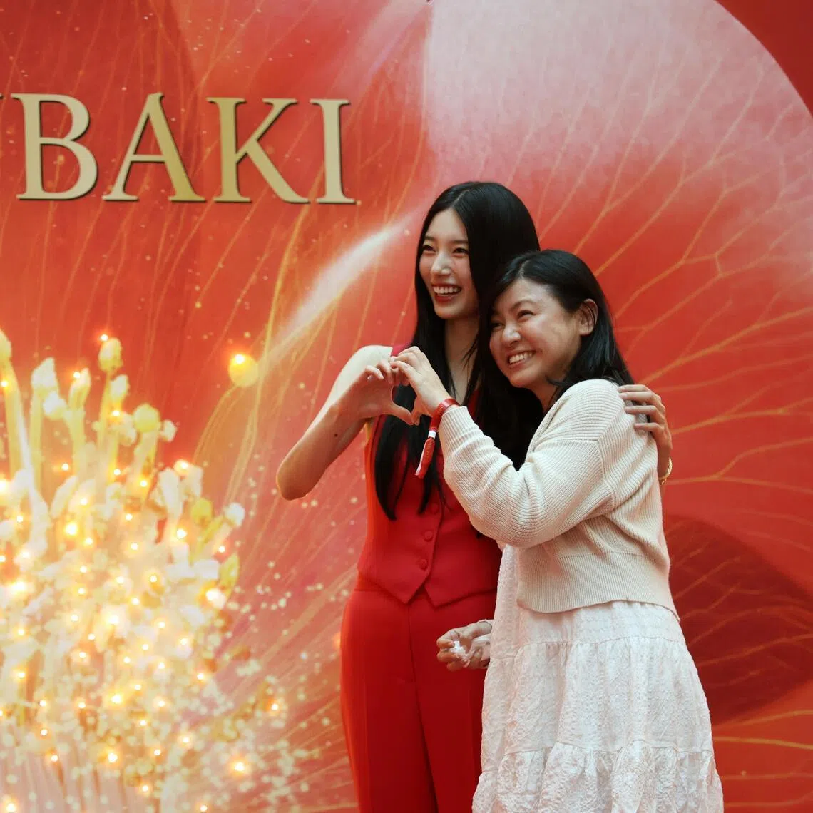 South Korean singer-actress Bae Suzy (left) poses for a Polaroid photo with Singaporean meet-and-greet winner Ong Poh Hoon at Tsubaki’s 20th anniversary pop-up in Plaza Singapura on July 17.