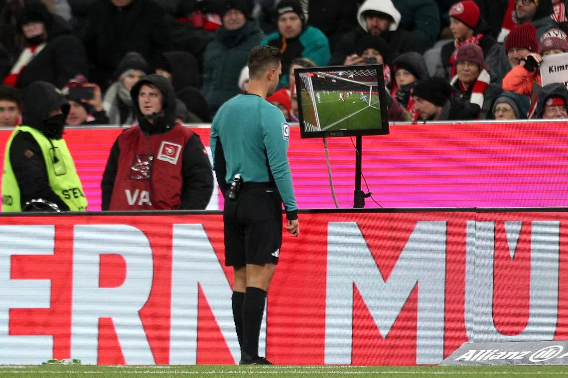 FILE PHOTO: Soccer Football - Bundesliga - Bayern Munich v FC Augsburg - Allianz Arena, Munich, Germany - November 22, 2024 Referee Daniel Schlager refers to VAR before he awards a penalty to Bayern Munich REUTERS/Leonhard Simon/File Photo