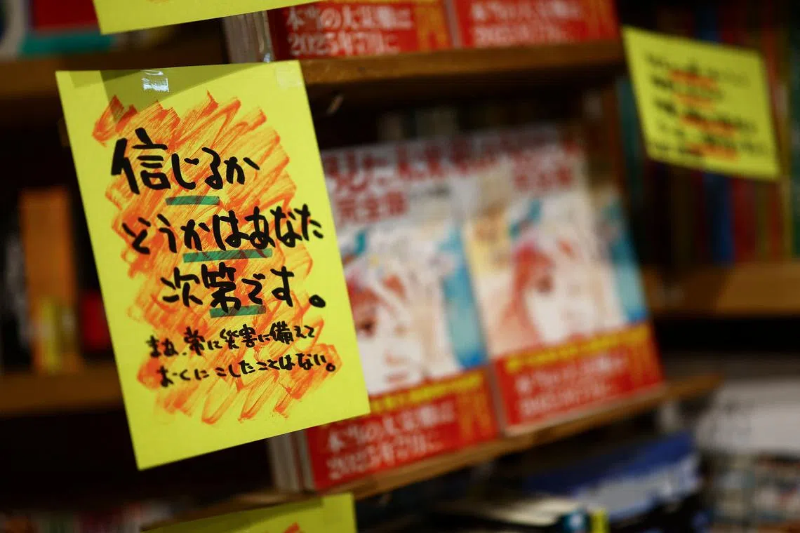 FILE PHOTO: A sales banner written by the store reading 'Whether you believe it or not is up to you' is displayed next to the comic book titled 'The Future I saw', authored by manga artist Ryo Tatsuki, on the shelf at the book store Village Vanguard in Tokyo, Japan June 30, 2025. REUTERS/Issei Kato/File Photo