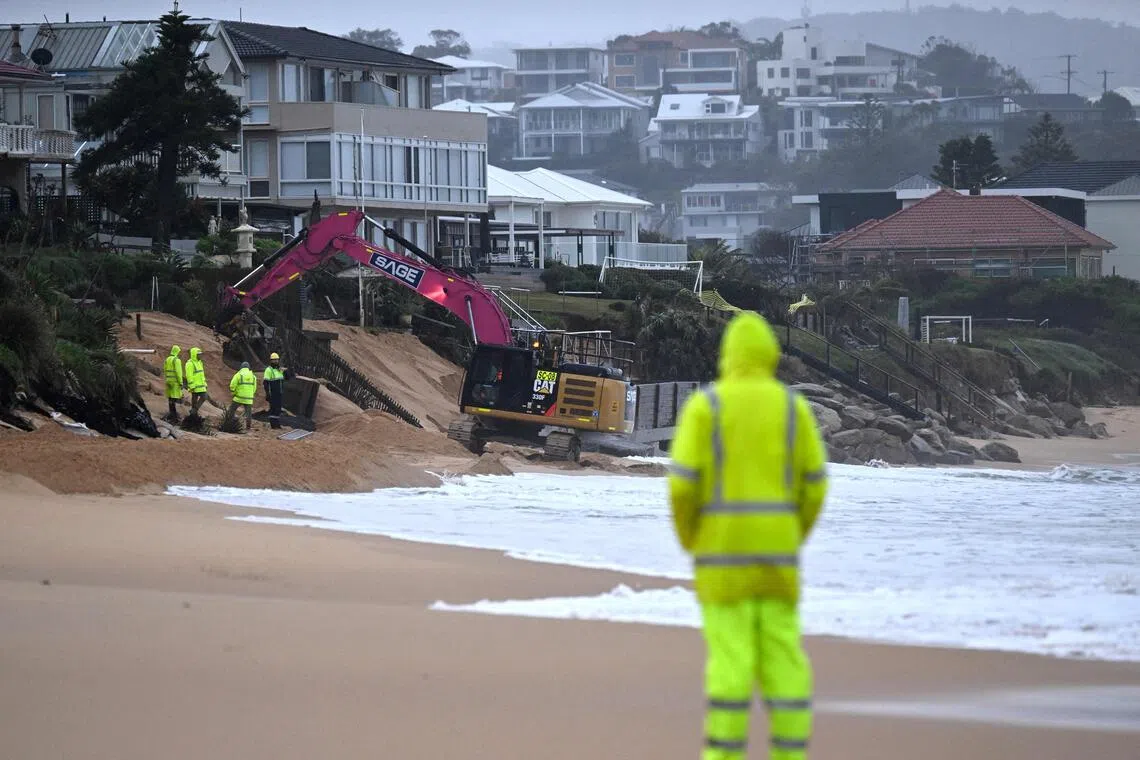 Workers operating heavy machinery to stabilise Wamberal Beach after it was lashed by a low-pressure cyclone on July 2, 2025.