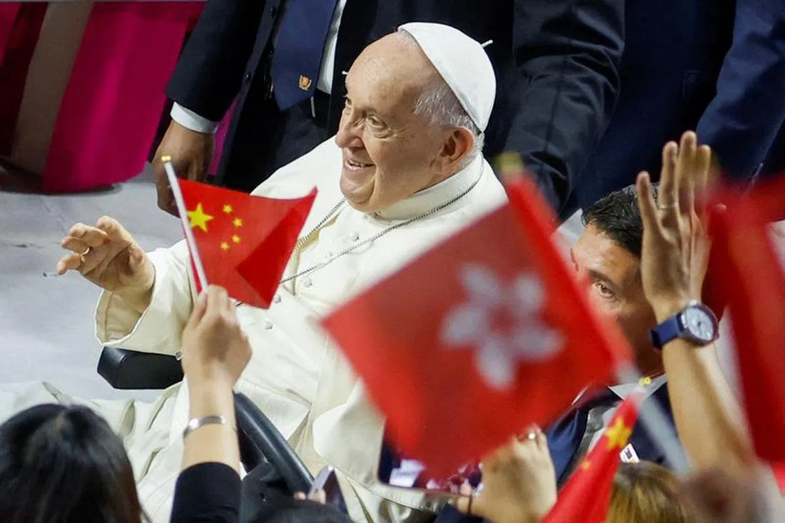 People wave Chinese and Hong Kong flags, as Pope Francis arrives to attend the Holy Mass in the Steppe Arena, during his Apostolic Journey in Ulaanbaatar, Mongolia September 3, 2023. REUTERS/Carlos Garcia Rawlins