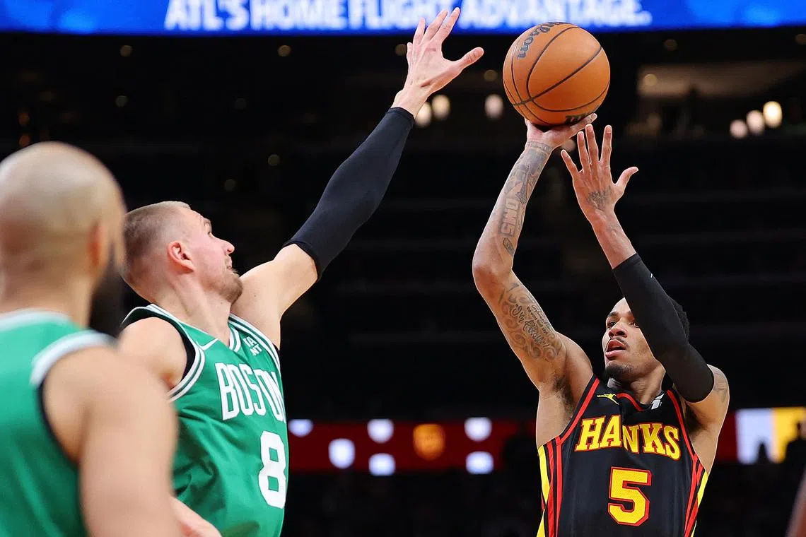 Dejounte Murray of the Atlanta Hawks shooting over Kristaps Porzingis of the Boston Celtics during overtime at State Farm Arena on March 28. Murray scored all 11 of the Hawks points in overtime, posting a career-high of 44 in Atlanta's 123-122 NBA win.