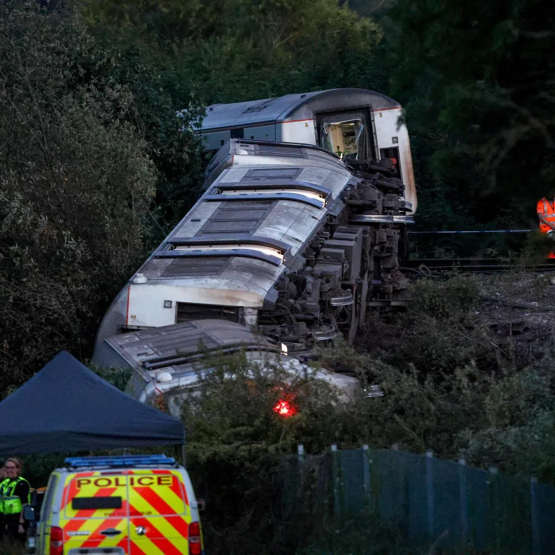 Emergency personnel working at the scene next to an overturned train after a passenger Southern service derailed near Lewes, south-east Britain, on Aug 13.