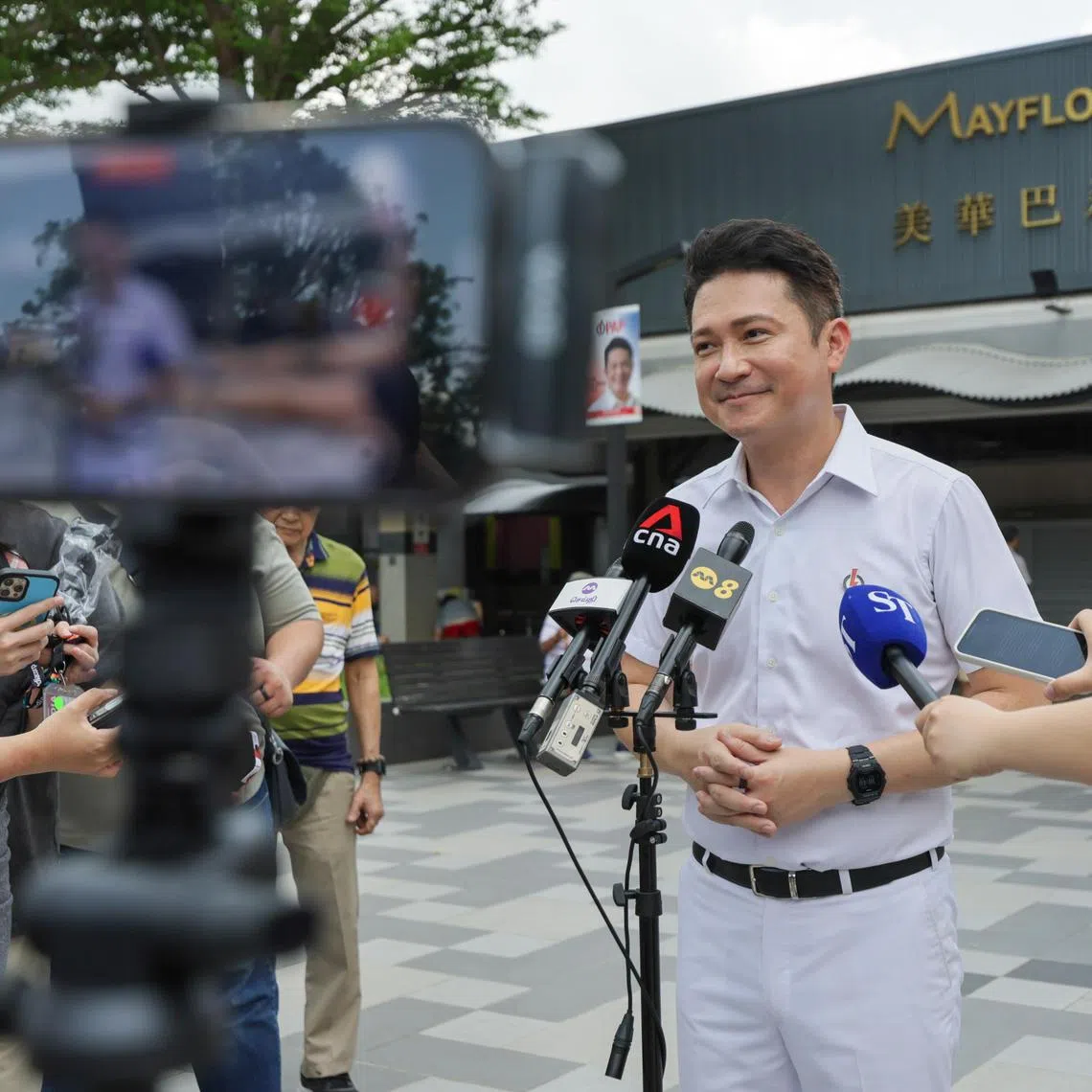 Mr Henry Kwek, the PAP candidate for Kebun Baru SMC speaking to the media during a walkabout at Mayflower Market & Food Centre on 25 April 2025