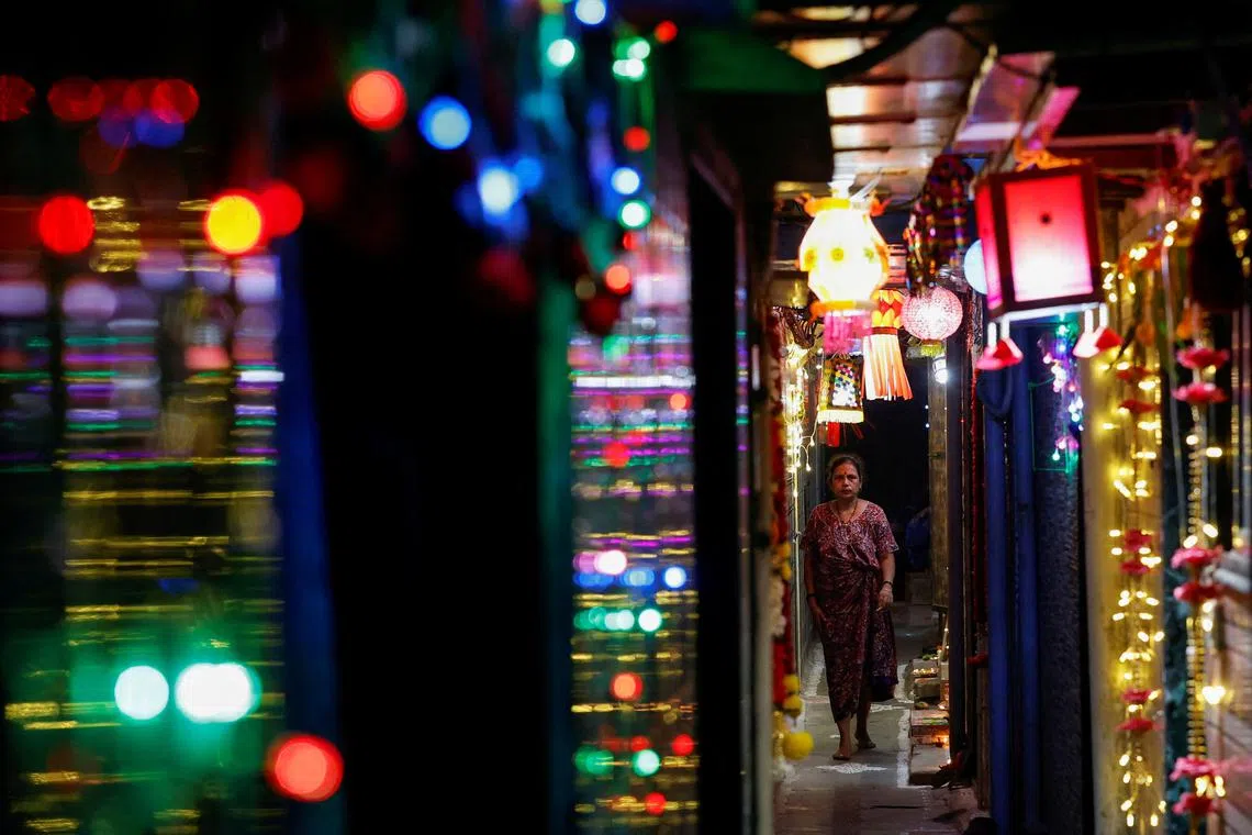 A woman walking through an alley decorated with lights and lanterns during Diwali, the Hindu festival of lights, in Mumbai, India, on Oct 31, 2024. 