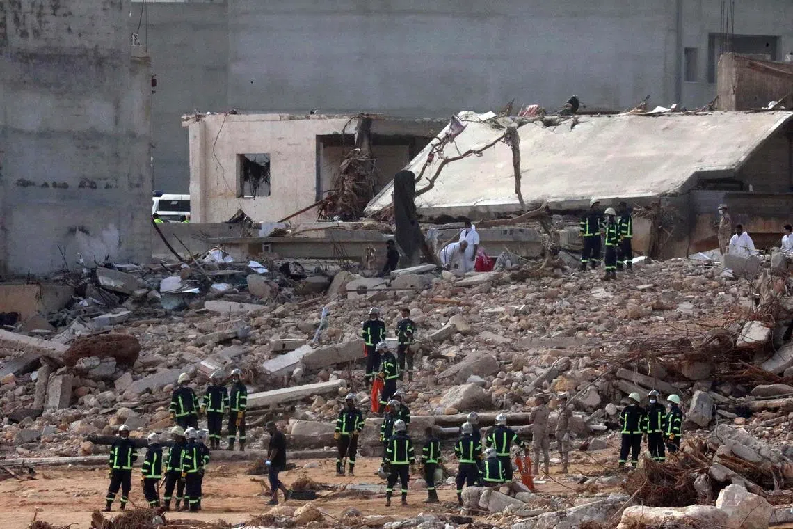 Rescuers gather amid the rubble of buildings damaged after the Mediterranean storm "Daniel" hit Derna, Libya on Sept 14.